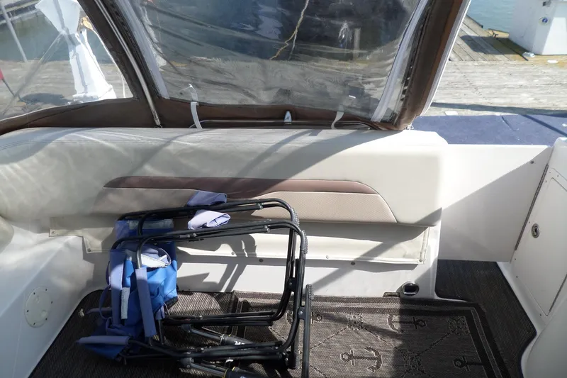 Slide: The Image of 2005 Chaparral Signature 270 boat interior with folded chairs and nautical-themed carpet. - 7