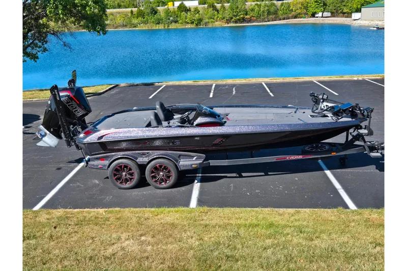 Slide: The Image of 2025 Vexus VX21 boat parked near a serene blue lake, showcasing sleek design and modern features. - 1
