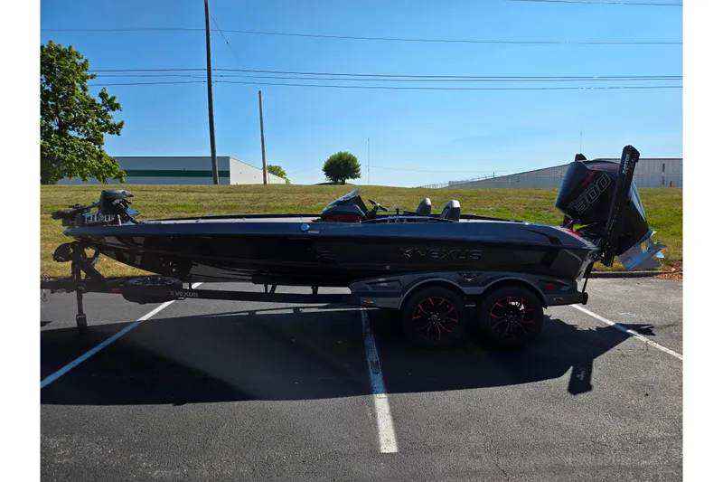 Slide: The Image of 2025 Vexus VX21 boat in parking lot, sleek black design, dual-axle trailer. - 7