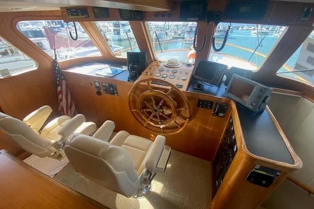 Slide: The Image of 1980 Willard Marine Pilothouse interior with wooden helm, navigation equipment, and dual captain chairs. - 12
