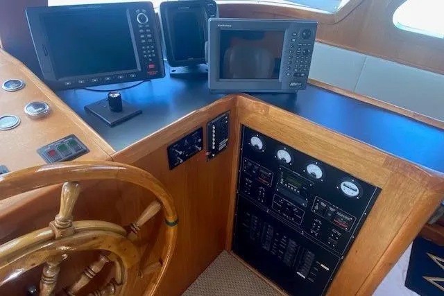 Slide: The Image of 1980 Willard Marine Pilothouse interior with navigation equipment and wooden steering wheel. - 13