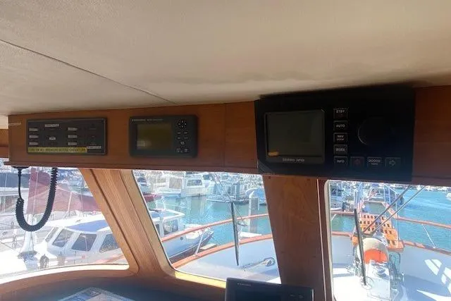 Slide: The Image of 1980 Willard Marine Pilothouse interior with navigation equipment and marina view. - 15