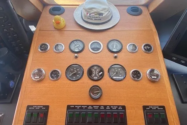 Slide: The Image of 1980 Willard Marine Pilothouse dashboard with gauges, controls, hat, and rubber duck. - 17