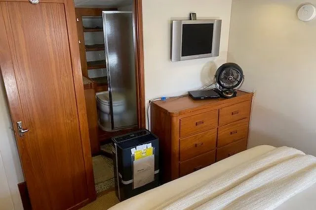 Slide: The Image of 1980 Willard Marine Pilothouse interior with wooden cabinetry, TV, and fan. - 20