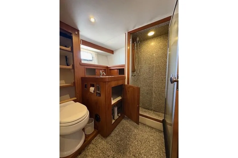 Slide: The Image of 1980 Willard Marine Pilothouse bathroom with shower, wooden cabinetry, and modern fixtures. - 21