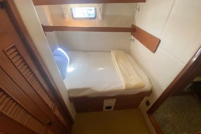 Slide: The Image of 1980 Willard Marine Pilothouse cabin interior with bed, window, and wooden accents. - 23