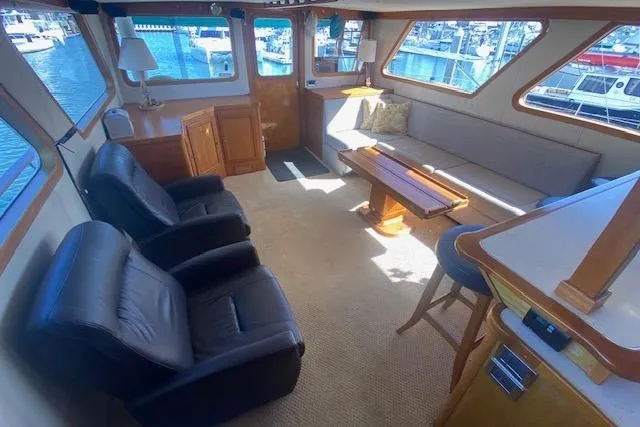 Slide: The Image of 1980 Willard Marine Pilothouse interior with leather chairs, sofa, and waterfront view. - 3