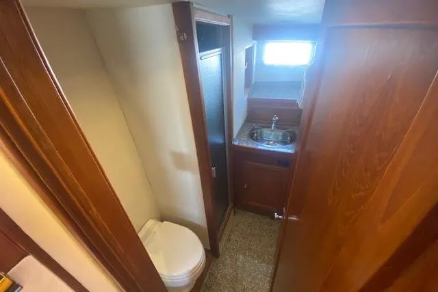 Slide: The Image of 1980 Willard Marine Pilothouse bathroom with sink, toilet, and wooden cabinetry. - 31