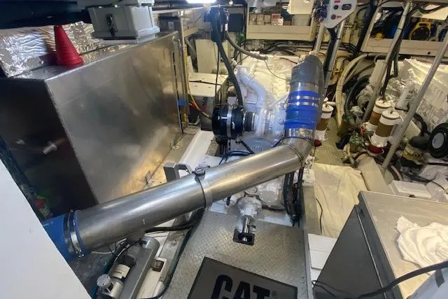 Slide: The Image of Engine room of a 1980 Willard Marine Pilothouse boat, featuring CAT machinery and piping. - 33