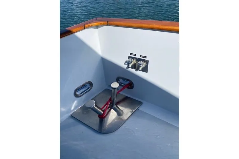 Slide: The Image of 1980 Willard Marine Pilothouse boat deck with cleats and valves, near water. - 54