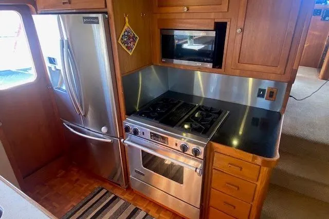 Slide: The Image of 1980 Willard Marine Pilothouse kitchen with stainless steel appliances and wooden cabinetry. - 8