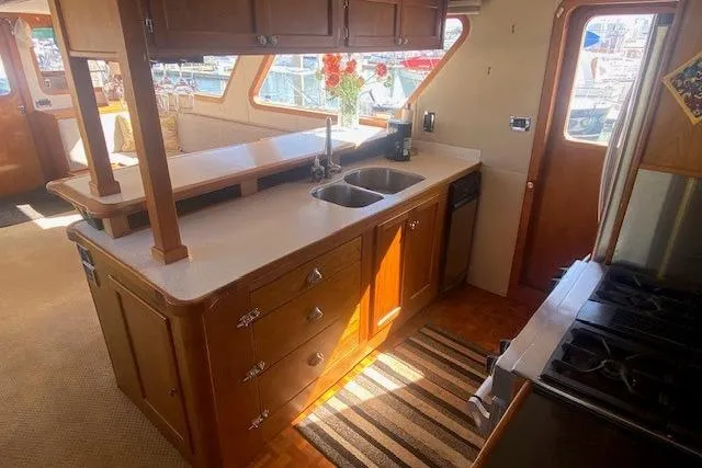 Slide: The Image of 1980 Willard Marine Pilothouse kitchen with wooden cabinetry, dual sink, and modern appliances. - 9