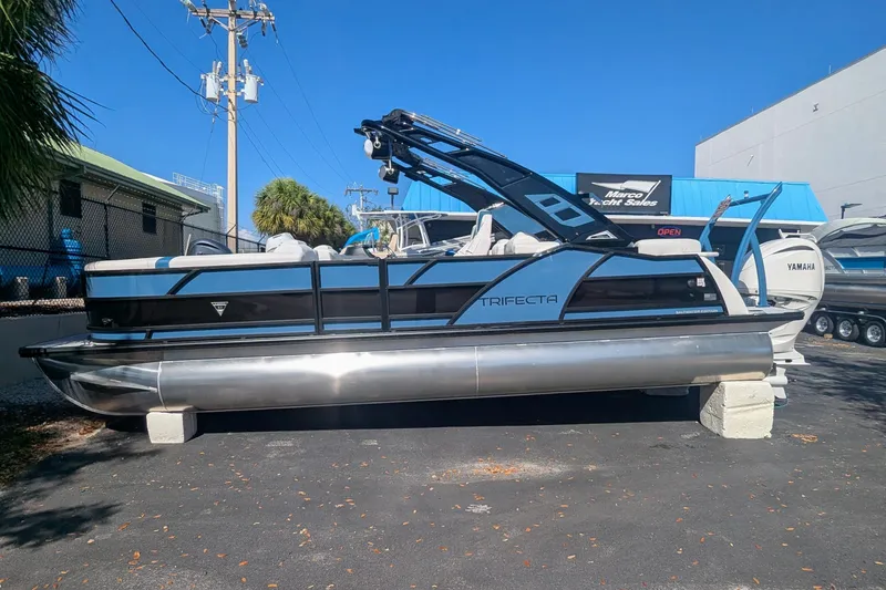 Slide: The Image of 2026 Trifecta 25RF SS pontoon boat displayed at a yacht sales lot. - 2