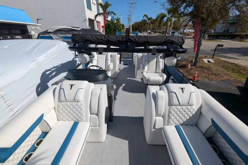 Slide: The Image of 2026 Trifecta 25RF SS pontoon boat with luxurious white and blue seating, docked outdoors. - 6