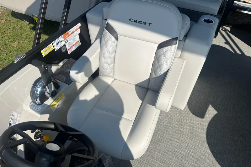Slide: The Image of 2025 Crest Classic 220 boat interior with luxurious captain's seat and steering controls. - 10