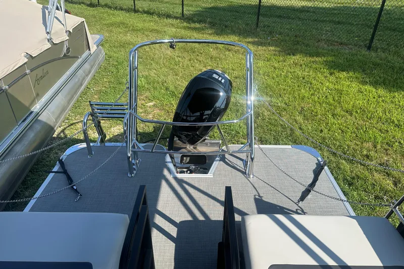 Slide: The Image of 2025 Crest Classic 220 pontoon boat with outboard motor, docked on grass. - 18