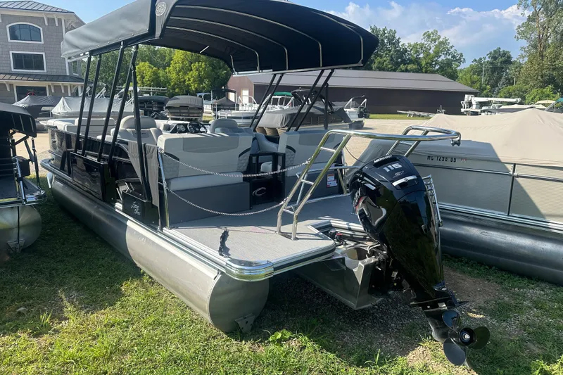 Slide: The Image of 2025 Crest Classic 220 pontoon boat with Mercury 115 outboard motor, docked outdoors. - 2