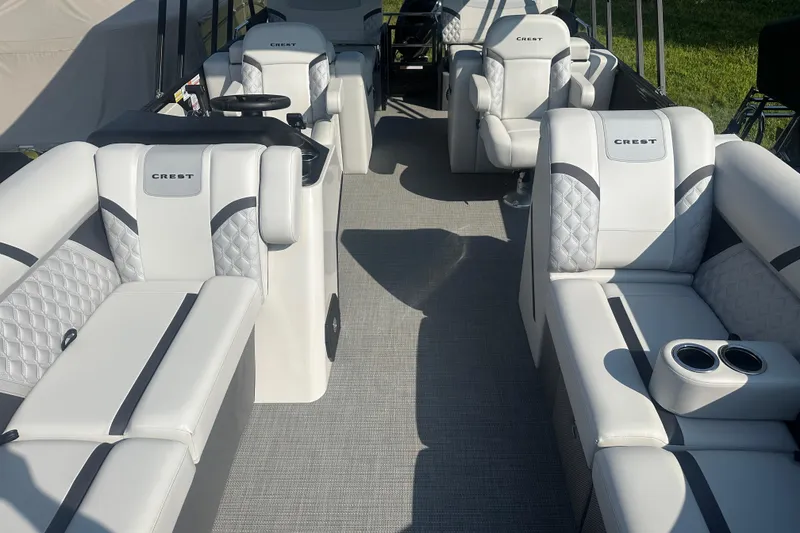 Slide: The Image of 2025 Crest Classic 220 boat interior with luxurious white seating and cup holders. - 4