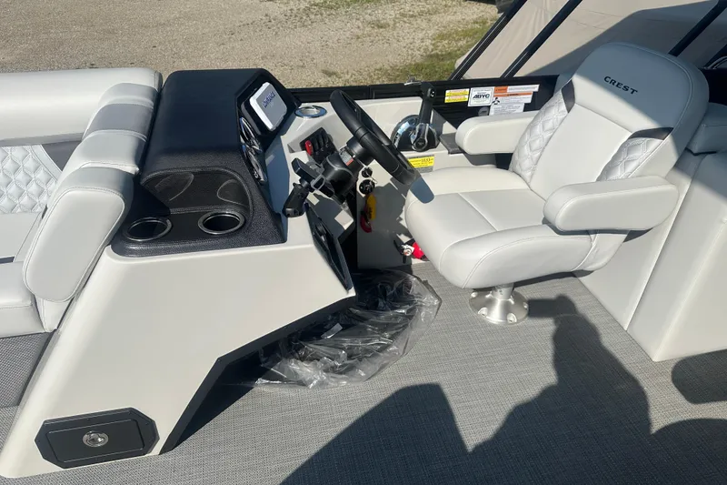 Slide: The Image of 2025 Crest Classic 220 boat interior with steering console and luxurious seating. - 7