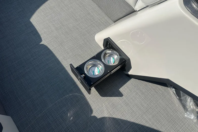 Slide: The Image of 2025 Crest Classic 220 boat interior with retractable cup holders on gray carpet. - 8