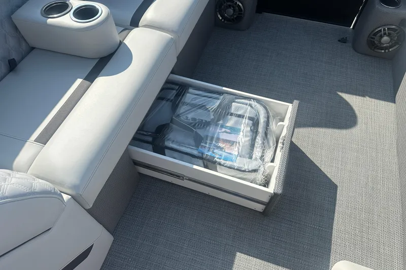 Slide: The Image of 2025 Crest Classic 220 boat interior with storage drawer and cup holders. - 9