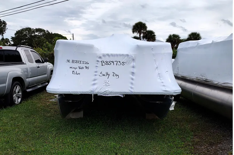 Slide: The Image of 2026 Sylvan Mirage 820 PARTY FISH boat covered in white tarp, parked outdoors. - 14