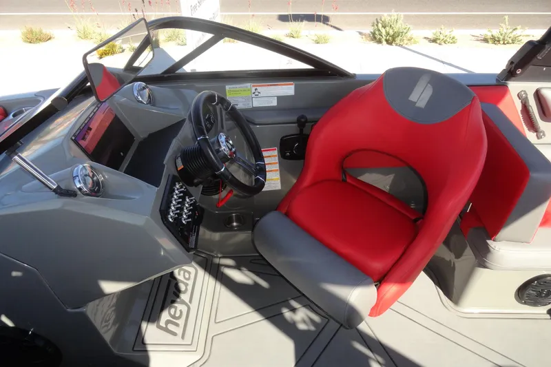 Slide: The Image of 2022 Heyday WT Surf boat cockpit with red and gray seating, steering wheel, and dashboard controls. - 11