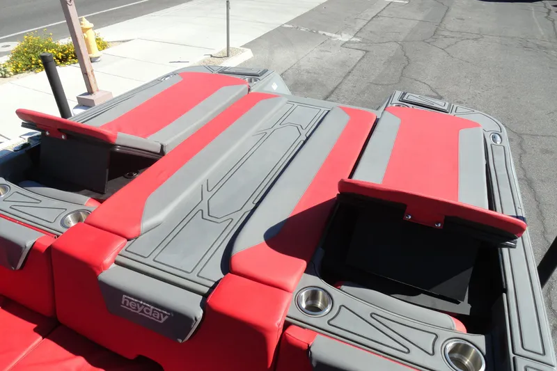 Slide: The Image of 2022 Heyday WT Surf boat with red and gray seating, cup holders, and sleek design. - 21