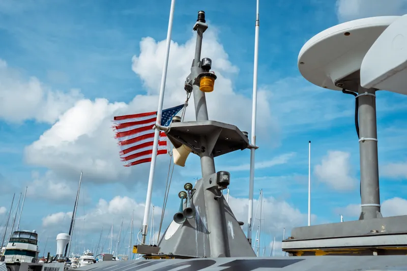 Slide: The Image of 2004 Kvichak Marine Industries Pilot boat with American flag, under a bright blue sky. - 14