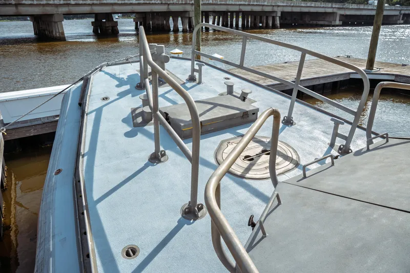 Slide: The Image of 2004 Kvichak Marine Industries Pilot boat deck with railings and hatch, docked by a bridge. - 15