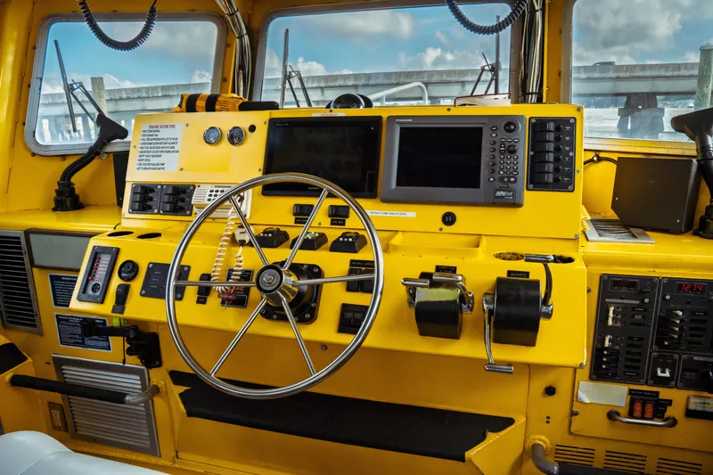 Slide: The Image of Yellow 2004 Kvichak Marine Industries Pilot boat cockpit with steering wheel and navigation equipment. - 31