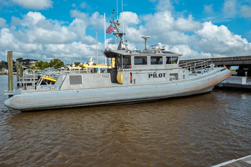 Slide: The Image of 2004 Kvichak Marine Industries Pilot boat docked, featuring a robust design and American flag. - 7