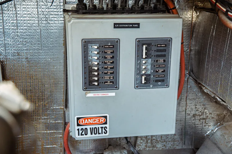 Slide: The Image of Electrical distribution panel with 120 volts warning on a 2004 Kvichak Marine Industries Pilot boat. - 73