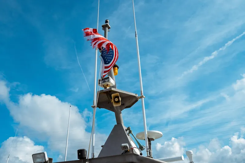 Slide: The Image of Pilot boat by Kvichak Marine Industries, 2004, with tattered American flag against blue sky. - 9