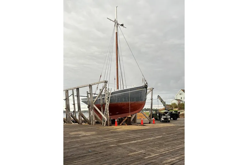 Slide: The Image of Custom 2004 Luke Powell Pilot Cutter on dry dock with crane and overcast sky. - 11