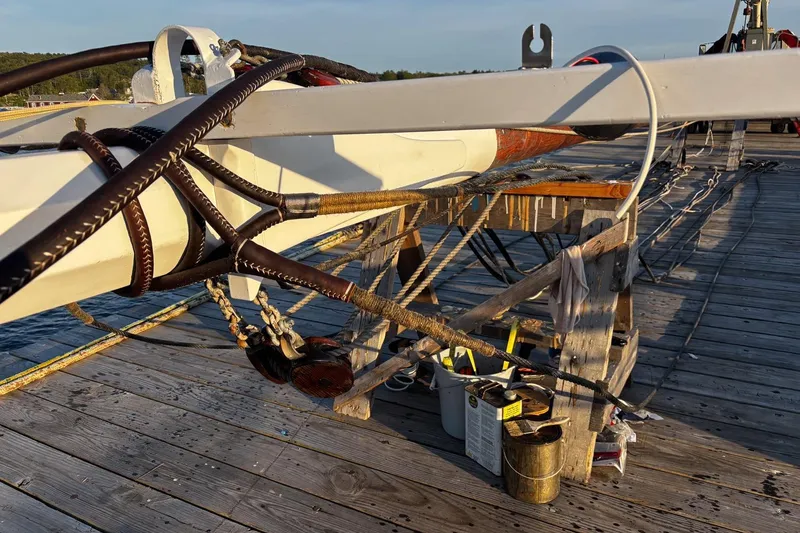 Slide: The Image of Rope and rigging on a 2004 Custom Luke Powell Pilot Cutter, docked on a wooden pier. - 17