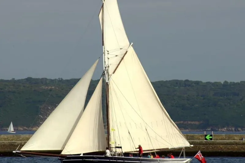Slide: The Image of Sailing on calm waters, a 2004 Luke Powell Pilot Cutter with full sails. - 2
