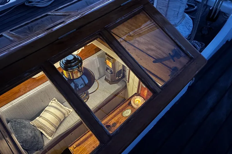 Slide: The Image of Cozy interior of 2004 Custom Luke Powell Pilot Cutter with cushions and lantern. - 21