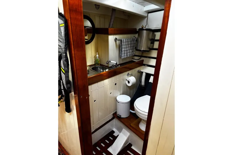 Slide: The Image of Compact bathroom in 2004 Custom Luke Powell Pilot Cutter, featuring wooden accents and nautical design. - 23