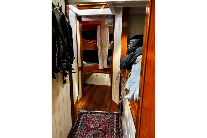 Slide: The Image of Cozy interior of 2004 Custom Luke Powell Pilot Cutter with wooden finishes and bunk beds. - 27