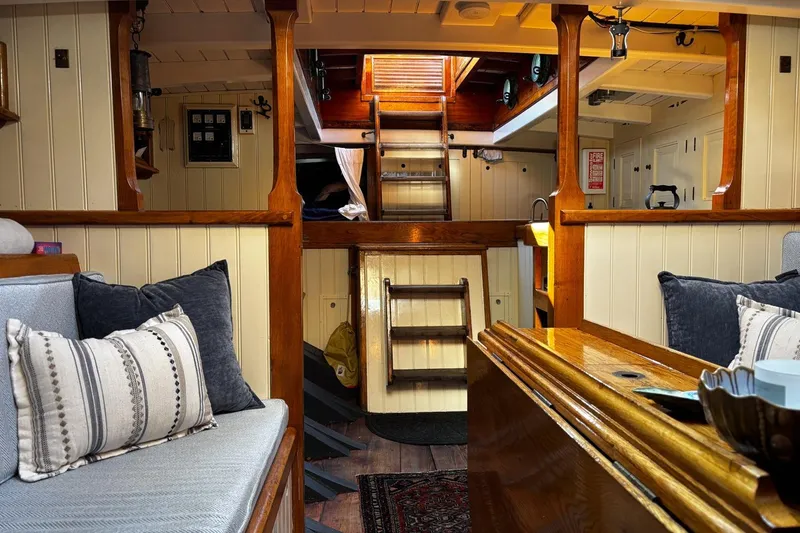 Slide: The Image of Cozy interior of 2004 Custom Luke Powell Pilot Cutter with wooden accents and comfortable seating. - 29