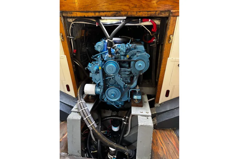 Slide: The Image of Engine of 2004 Custom Luke Powell Pilot Cutter, showcasing mechanical components and wooden surroundings. - 34