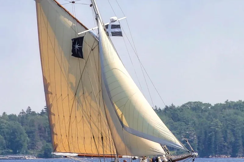 Slide: The Image of Sailing on a 2004 Custom Luke Powell Pilot Cutter with tanbark sails and forest backdrop. - 4