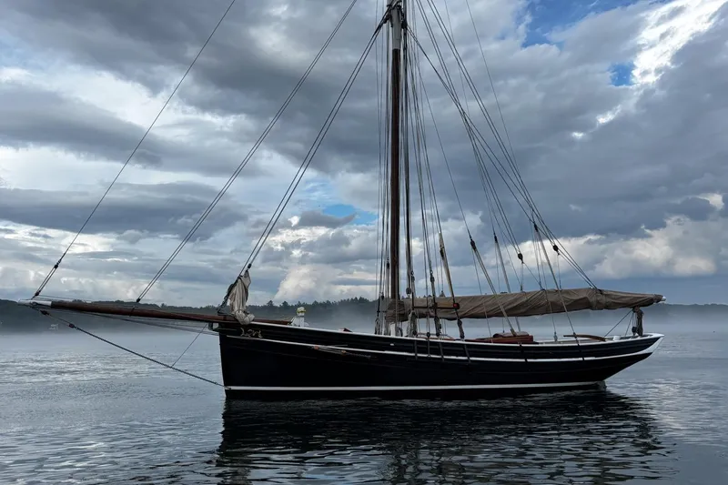 Slide: The Image of Custom 2004 Luke Powell Pilot Cutter sailing on misty waters under cloudy skies. - 9