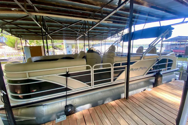The Image of 2014 AquaPatio 220 WB pontoon boat docked under a covered marina. - 0