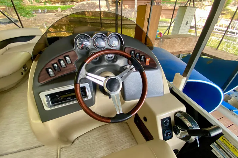 Slide: The Image of Steering console of a 2014 AquaPatio 220 WB boat with gauges and controls. - 13