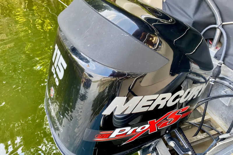 Slide: The Image of Mercury Pro XS 115 outboard motor on 2014 AquaPatio 220 WB boat, docked in water. - 23