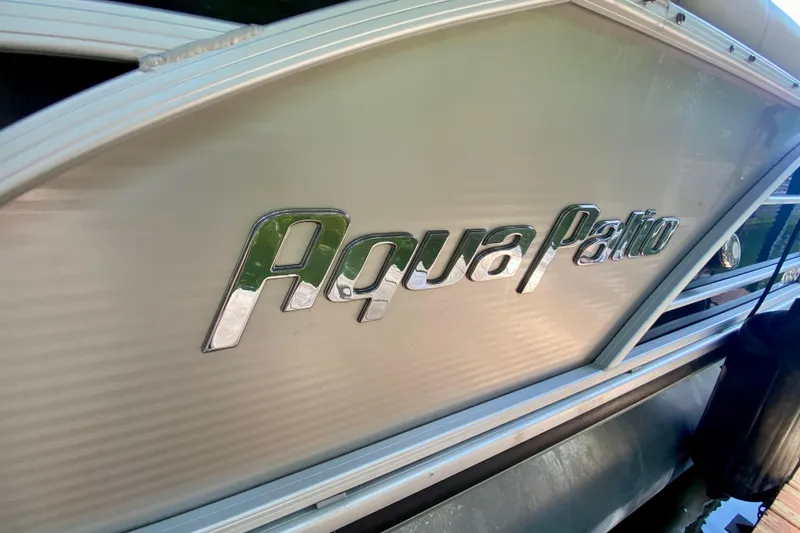 Slide: The Image of 2014 AquaPatio 220 WB boat with metallic logo on side panel. - 27