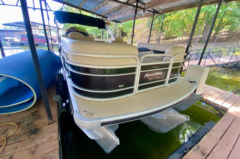 Slide: The Image of 2014 AquaPatio 220 WB pontoon boat docked under a covered structure. - 4