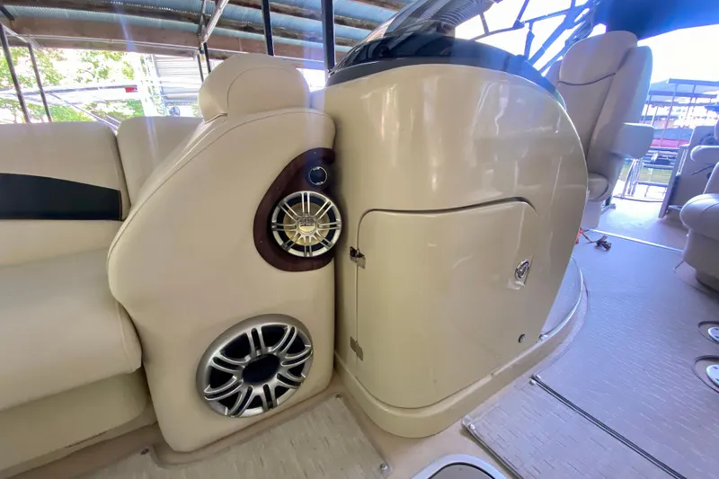 Slide: The Image of 2014 AquaPatio 220 WB boat interior with beige seating and built-in speakers. - 7